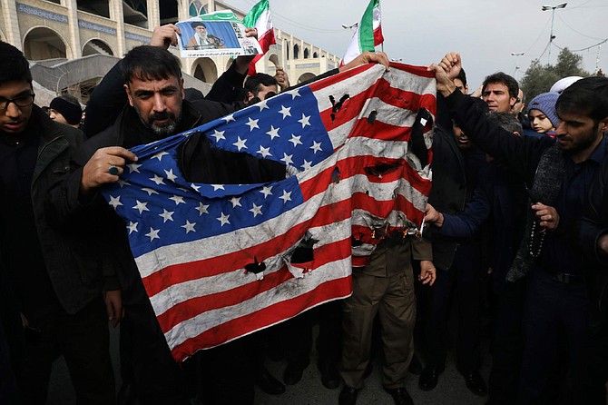 Protesters burn a U.S. flag during a demonstration over the U.S. airstrike in Iraq that killed Iranian Revolutionary Guard Gen. Qassem Soleimani, in Tehran, Iran, Jan. 3, 2020. Iran has vowed &quot;harsh retaliation&quot; for the U.S. airstrike near Baghdad&#039;s airport that killed Tehran&#039;s top general and the architect of its interventions across the Middle East, as tensions soared in the wake of the targeted killing. (AP Photo/Vahid Salemi)