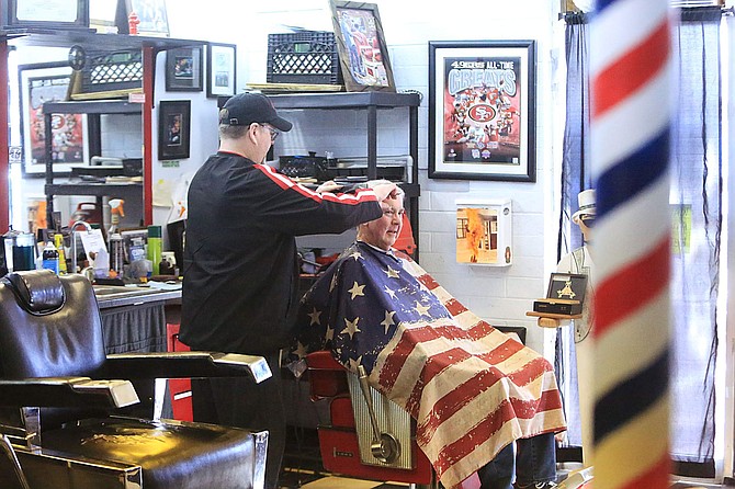 Jeff Nichols, owner of Capital Barbershop, cuts the hair of Steve Redmond of Gardnerville Friday afternoon. Nichols, an adamant 49ers fan, wore red and black while saying San Francisco will win Super Bowl LIV, 31-27.