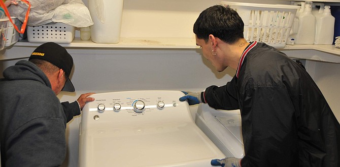 Angel Olvera, left, and Martin Hernandez of Northern Nevada Appliance Outlet install a General Electric dryer on Friday at Western Nevada College. Northern Nevada Appliance Outlet donated a new dryer and washer for the Child Development Center.
