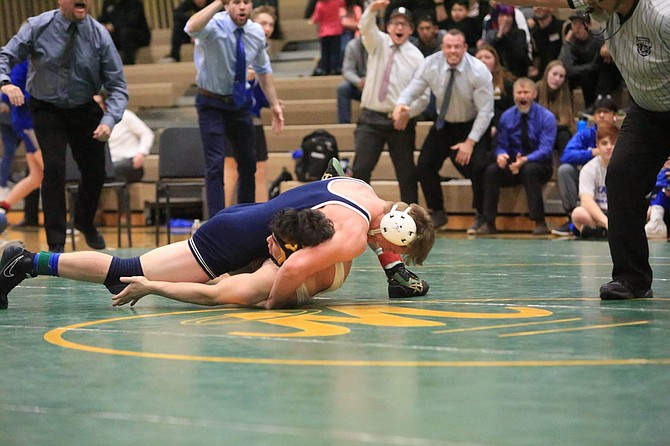 Carson 160-pound wrestler Alex Wells nears a pin during his final match Saturday afternoon as the Carson high coaching staff reacts in the background. 