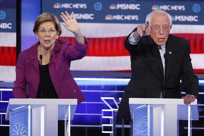 Democratic presidential candidates, Sen. Elizabeth Warren, D-Mass., left, and Sen. Bernie Sanders, I-Vt., try to answer a question during a Democratic presidential primary debate Wednesday, Feb. 19, 2020, in Las Vegas, hosted by NBC News and MSNBC. (AP Photo/John Locher)