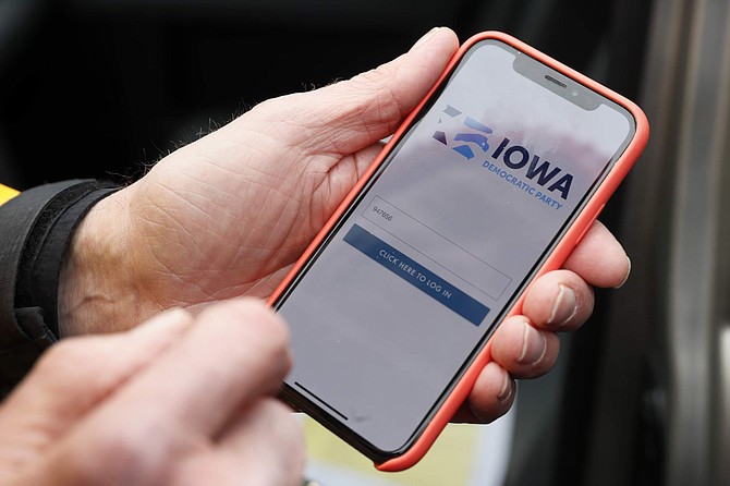 Precinct captain Carl Voss, of Des Moines, Iowa, holds his iPhone that shows the Iowa Democratic Party&#039;s caucus reporting app Tuesday, Feb. 4, 2020, in Des Moines, Iowa. (AP Photo/Charlie Neibergall)