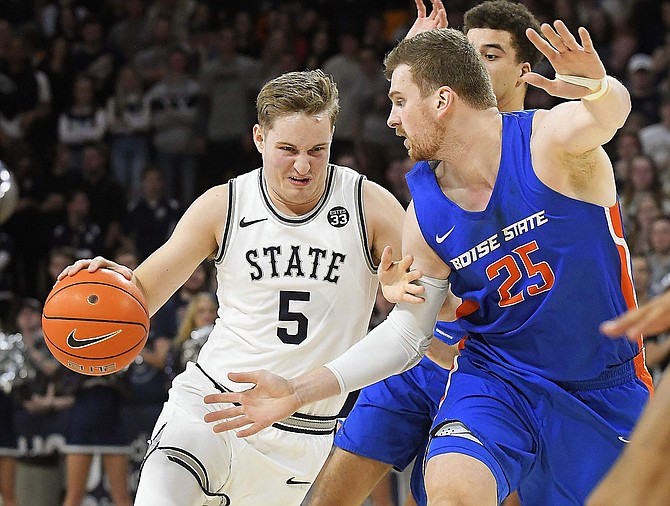 Utah State guard Sam Merrill (5) drives to the basket as Boise State center Robin Jorch (25) defends during the second half of an NCAA college basketball game Saturday, Feb. 8, 2020, in Logan, Utah. (Eli Lucero/The Herald Journal via AP)