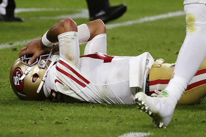 San Francisco 49ers quarterback Jimmy Garoppolo lays on the ground after being hit during the second half of Super Bowl 54.