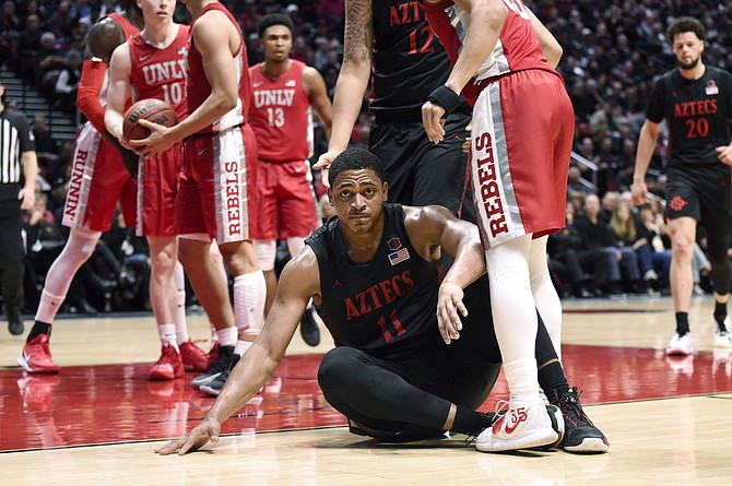 San Diego State forward Matt Mitchell (11) sits of the court after being fouled during the first half of an NCAA college basketball game against UNLV Saturday, Feb. 22, 2020, in San Diego. (AP Photo/Denis Poroy)