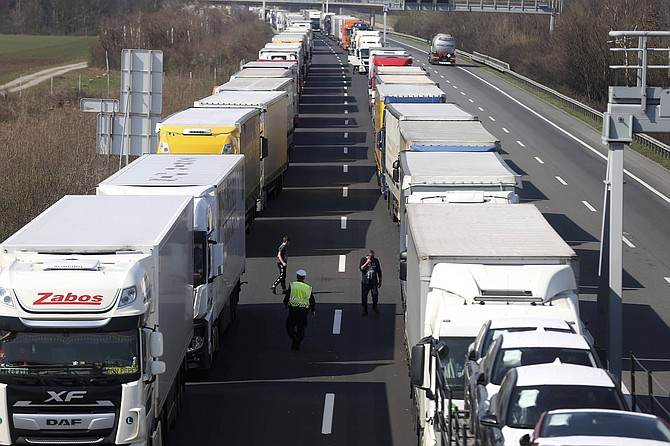 Trucks stand on the highway close to the border between Austria and Hungary near Bruck an der Leitha, Austria, Wednesday, March 18, 2020. Hungary has closed the border due to the new coronavirus outbreak. Only for most people, the new coronavirus causes only mild or moderate symptoms, such as fever and cough. For some, especially older adults and people with existing health problems, it can cause more severe illness, including pneumonia. 