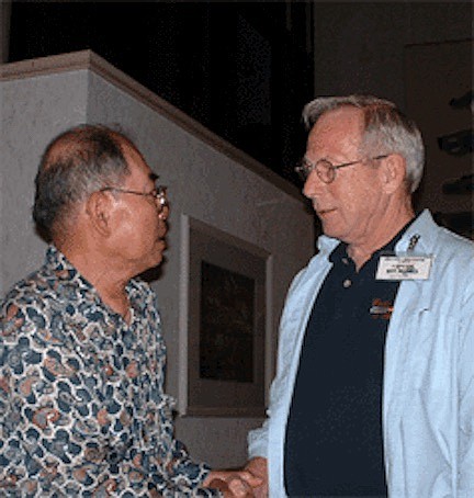 Candido (Pop) Badua and Ray Alcorn speak at a 30-year reunion for POWs in 2003.