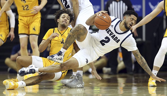 CORRECTS NEVADA PLAYER TO JALEN HARRIS, INSTEAD OF VANCE JACKSON - Wyoming&#039;s Kwane Marble II and Nevada&#039;s Jalen Harris (2) fall to the court during the first half of a Mountain West Conference tournament NCAA college basketball game Thursday, March 5, 2020, in Las Vegas. Marble was called for a foul. (AP Photo/Isaac Brekken)