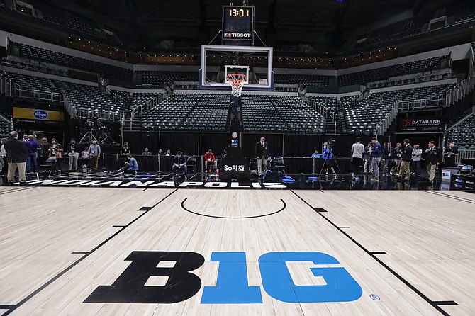 The seating area at Bankers Life Fieldhouse is empty as media and staff mill about, Thursday, March 12, 2020, in Indianapolis, after the Big Ten Conference announced that remainder of the men&#039;s NCAA college basketball games tournament was cancelled.