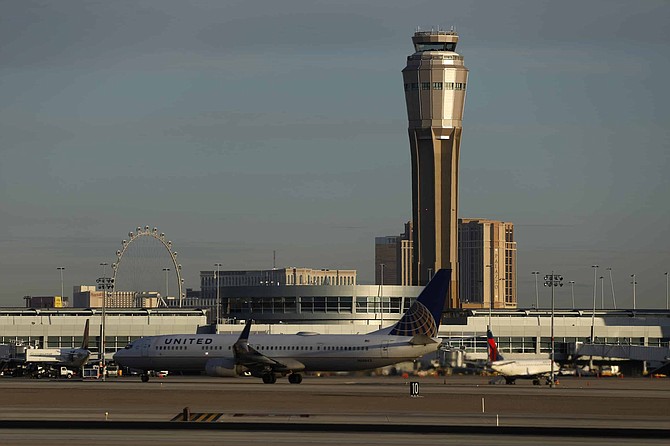A plane takes off at McCarran International airport, Thursday, March 19, 2020, in Las Vegas.   Officials at  the airport said in a tweet that it will remain open with reduced operations after an air traffic controller tested positive late Wednesday, temporarily closing the control tower.  