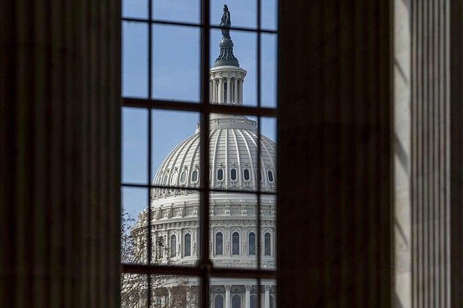 The Capitol is framed through a window in the Russell Senate Office Building as lawmakers negotiate on the emergency coronavirus response legislation, at the Capitol in Washington, Wednesday, March 18, 2020. 