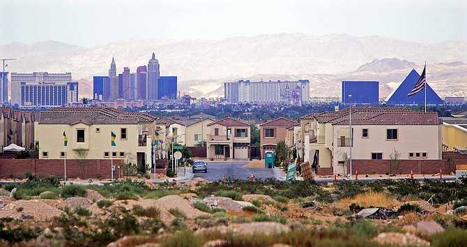 FILE - This Aug. 15, 2005, file photo, shows a housing development with the Las Vegas Strip in the background. Las Vegas-area home prices hit a record high in March, ahead of the economic shutdown prompted by the coronavirus pandemic. Las Vegas Realtors reported Tuesday, April 7, 2020, the median sales price of previously owned single-family homes climbed to $319,000, topping the previous record $316,000 set in February and up 6.3% from March 2019. Home sales were up 5.2% during the month, and up 11.7% for condominiums and townhouses. 