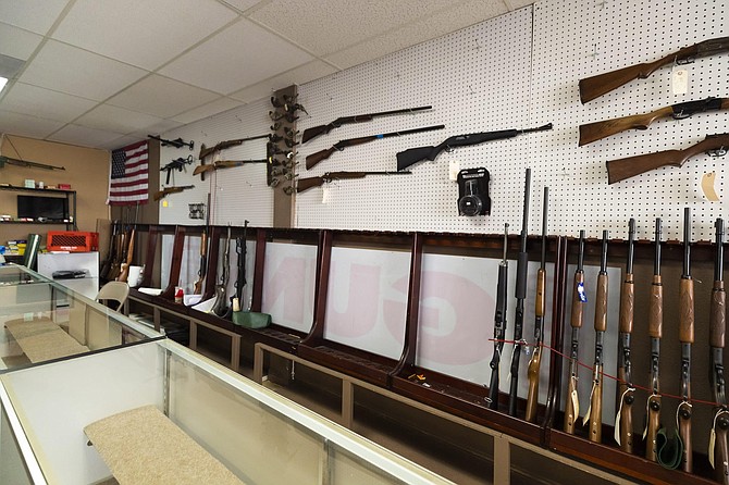 In this Monday, April 6, 2020, photo, a rifle display is half empty at Elite Firearms in Las Vegas. Joe Potter, a sales associate at the store, says he ran 475 firearm background checks in a three week period. (Wade Vandervort/Las Vegas Sun via AP)