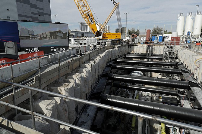 FILE - In this Nov. 15, 2019, file photo, a tunnel boring machine sits at the bottom of a construction site during a media tour at the Las Vegas Convention Center in Las Vegas.  Workers have completed the second of two underground tunnels for a people mover connecting exhibit halls at the expanded Las Vegas Convention Center. A spokeswoman says a drilling machine reached the end of the nearly 1-mile (1.6-kilometer) tunnel a little before 1 a.m. Thursday, May 14, 2020. 
