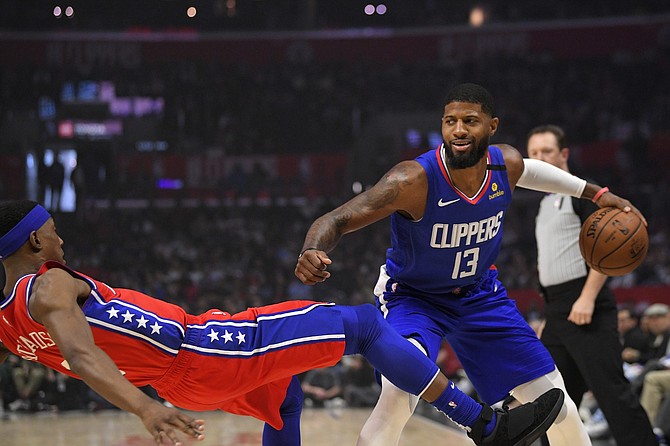 Philadelphia 76ers guard Josh Richardson, left, goes down as Los Angeles Clippers guard Paul George tries to drive past him during the first half of an NBA basketball game Sunday, Mar. 1, 2020, in Los Angeles. 