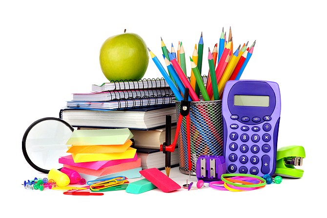 Books and a colorful assortment of school supplies isolated on a white background