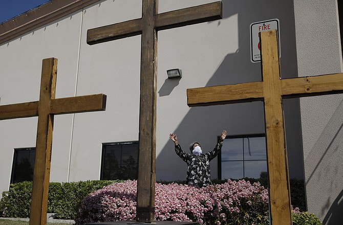 FILE - In this April 12, 2020, file photo, Norma Urrabazo prays while wearing a face mask before speaking at an Easter drive-in service at the International Church of Las Vegas, in Las Vegas. Nevada&#039;s lawyers are stepping up their defense of Gov. Steve Sisolak&#039;s 50-person cap on religious gatherings in a legal battle with leaders of Calvary Chapel Dayton Valley, a rural church who say it violates their constitutional right to exercise their beliefs. 