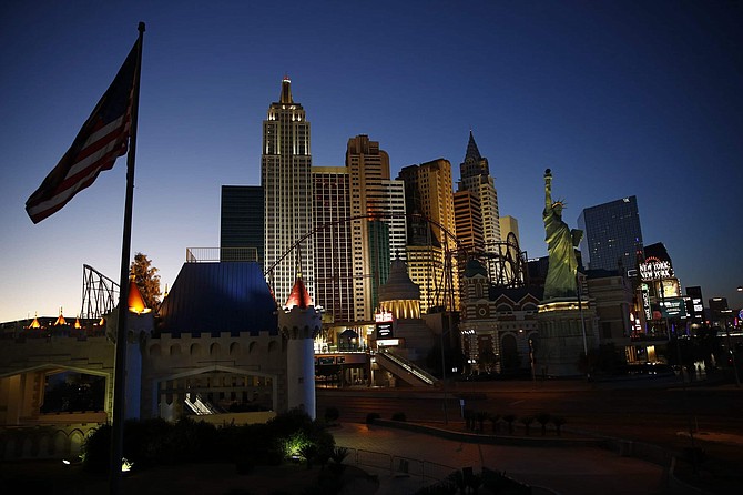 FILE - In this April 28, 2020, file photo, the sun sets behind casinos and hotels along the Las Vegas Strip in Las Vegas. Unions representing 65,000 Las Vegas-area casino workers are suing some resort operators, alleging that employees are being put at risk of illness and death due to skimpy safety measures during the coronavirus pandemic. A lawsuit filed Monday, June 29, 2020, in U.S. District Court in Las Vegas does not directly cite the death last week of Adolfo Fernandez, a 51-year-old Caesars Palace porter and union member who was diagnosed with the COVID-19 respiratory illness after returning to work when casinos reopened June 4. 