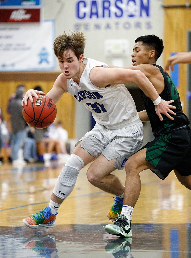 Nate Smothers of Carson High drives past a Hug defender this past winter. Smothers will continue his basketball career at Lassen College next season after signing his National Letter of Intent on Monday. 