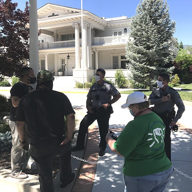 AFSCME Local 4041 members stand outside of the Governor&#039;s mansion talking to police Saturday afternoon. State&#039;s workers were out protesting the state&#039;s proposed budget cuts. 