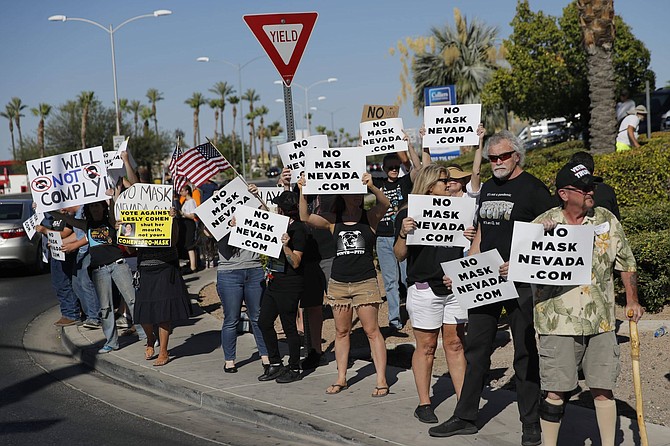 People protest Nevada&#039;s public mask mandate Wednesday, July 8, 2020, in Henderson, Nev. Nevada Gov. Steve Sisolak issued a mandatory face covering policy for public spaces throughout the state due to the coronavirus. 