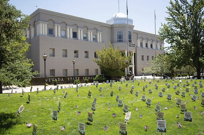 Signs reading &quot;Don&#039;t Raise our Taxes,&quot; sponsored by Americans for Prosperity, stand in the grass outside the Nevada Legislature in Carson City, Nev., Thursday, July 16, 2020. 