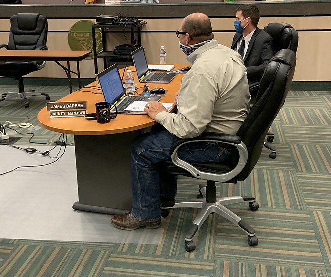 County manager Jim Barbee, left, addresses the commission at a special meeting on Friday with Benjamin Shawcraft, chief civil deputy district attorney.