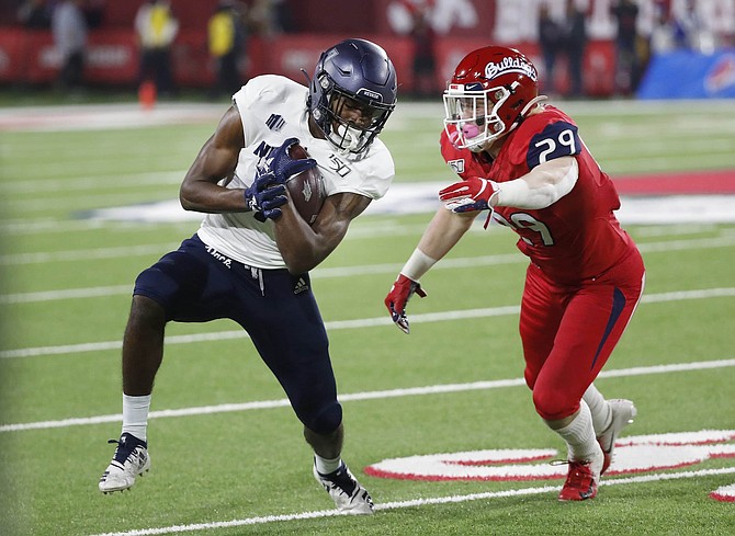 Nevada wide receiver Romeo Doubs runs for yards as Fresno State linebacker Justin Rice tries to hold on during the first half of an NCAA college football game in Fresno, Calif., Saturday, Nov. 23, 2019. 