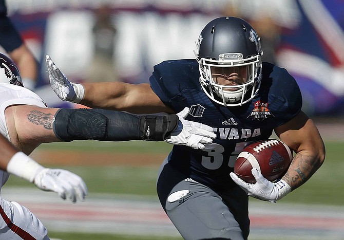 FILE - In this Dec. 29, 2018, file photo, Nevada running back Toa Taua (35) carries during the first half of the Arizona Bowl NCAA college football bowl game against Arkansas State in Tucson, Ariz. Nevada sophomore running back Taua rushed for 872 yards and six TDs last year for Nevada. Coming off breakout freshman seasons, Purdue wide receiver Rondale Moore and Nevada&#039;s Taua headline Friday night&#039;s non-conference opener on the edge of the Sierra where both third-year coaches hope to turn the corner on rebuilding efforts. (AP Photo/Rick Scuteri, File)