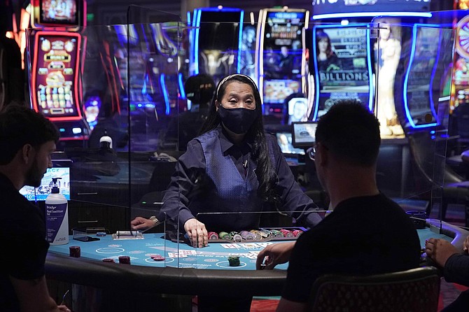 In this June 4 photo, people play blackjack at the reopening of the Bellagio hotel and casino in Las Vegas. 