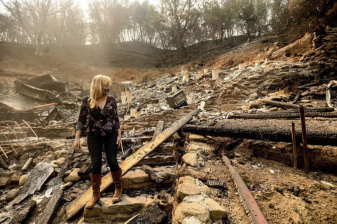 Pam, who declined to give a last name, examines the remains of her partner&#039;s Vacaville, Calif., home on Friday, Aug. 21, 2020. The residence burned as the LNU Lightning Complex fires ripped through the area Tuesday night. (AP Photo/Noah Berger)