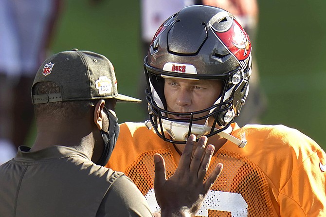 FILE - Tampa Bay Buccaneers quarterback Tom Brady talks to offensive coordinator Byron Leftwich during an NFL football training camp practice Friday, Aug. 28, 2020, in Tampa, Fla.