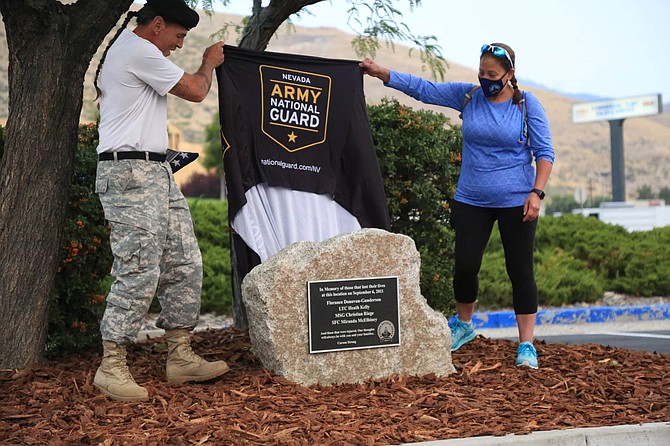 Retired Nevada Guard Maj. Kenneth Curtzwiler and Lt. Col. Laura Boldry pull off the cover of the plaque honoring the victims of the 2011 IHOP shooting. The plaque sits in the parking lot of Chase Bank, on the site that was formerly the IHOP. 