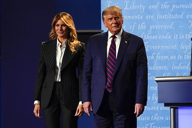 President Donald Trump stands on stage with first lady Melania Trump after the first presidential debate with Democratic presidential candidate former Vice President Joe Biden Tuesday, Sept. 29, 2020, at Case Western University and Cleveland Clinic, in Cleveland, Ohio. (AP Photo/Julio Cortez)
