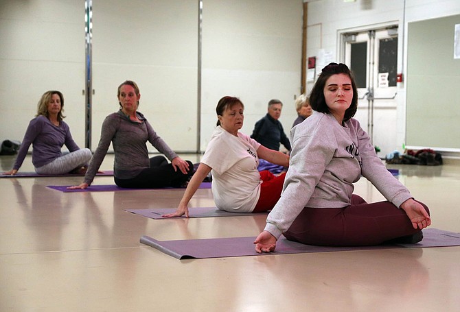 Aadra Reed, right, meditates during a Wellness Yoga session on Monday, Dec. 16, 2019 at the Carson City Community Center.
