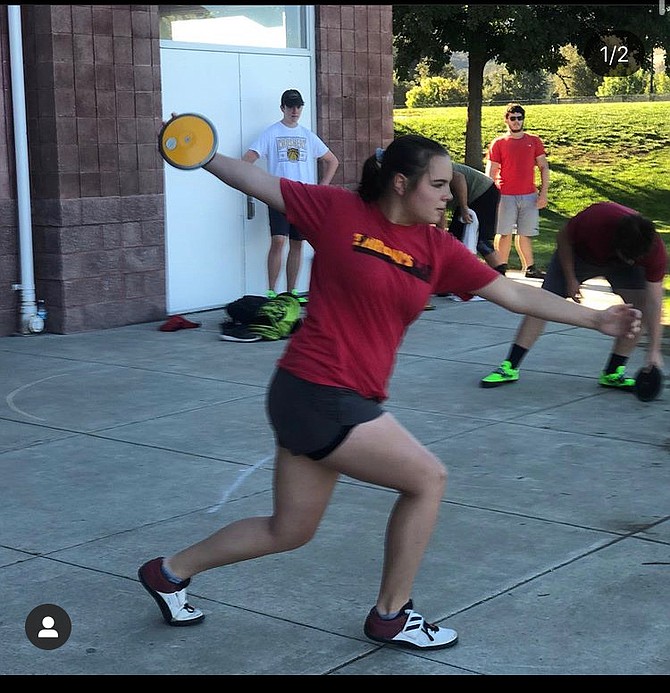 Katelyn Howerton practices her discus rotations in a driveway. Howerton has committed to throw at Bryant University following her senior year. 