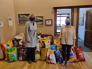 Victoria Williams, right, Coldwell Banker Select managing broker, presents more than 435 pounds of pet food to Genevieve Frederick, left, founder and president of Feeding Pets of the Homeless.