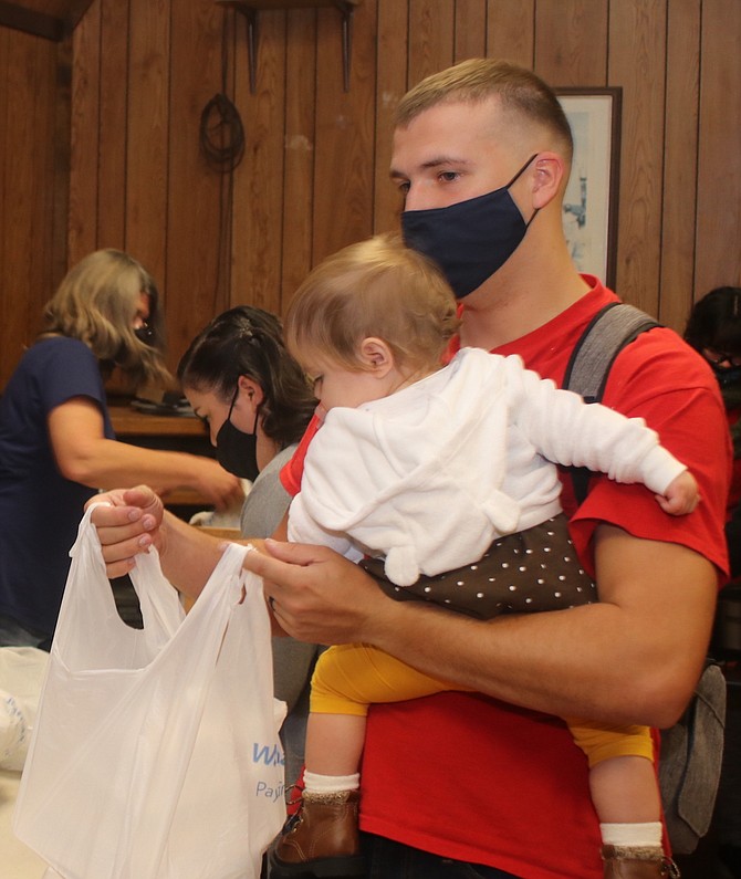 A02 Tyler Nicloet balances his daughter in one arm whole volunteering on Thanksgiving Day.