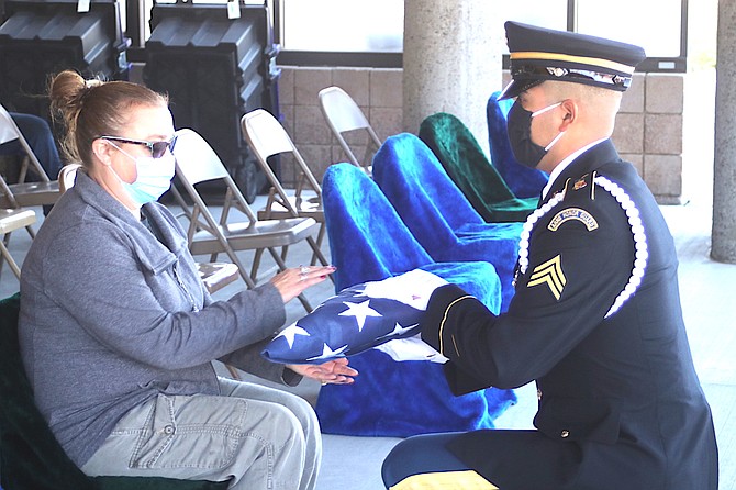 Nevada Army National Guard soldier Sgt. Manuel Monroy presents the flag to Kristin Kowalski McFarlane at the last unaccompanied service at the Northern Nevada Veterans Memorial Cemetery.
