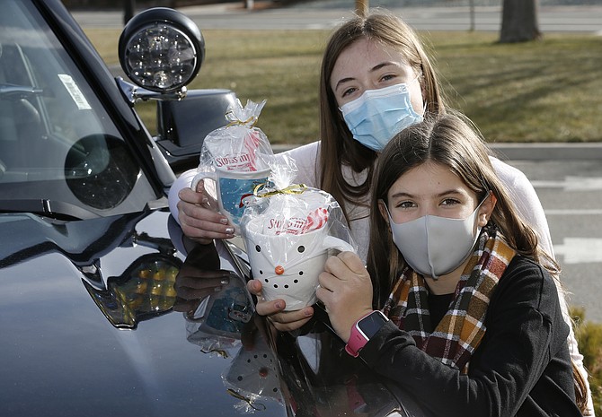 Carson Middle schoolers Kylie Green, 13, left, and Riley Kuhlman, 11, raised more than $1,200 for the Holiday with a Hero program by creating and selling holiday coffee mugs.
