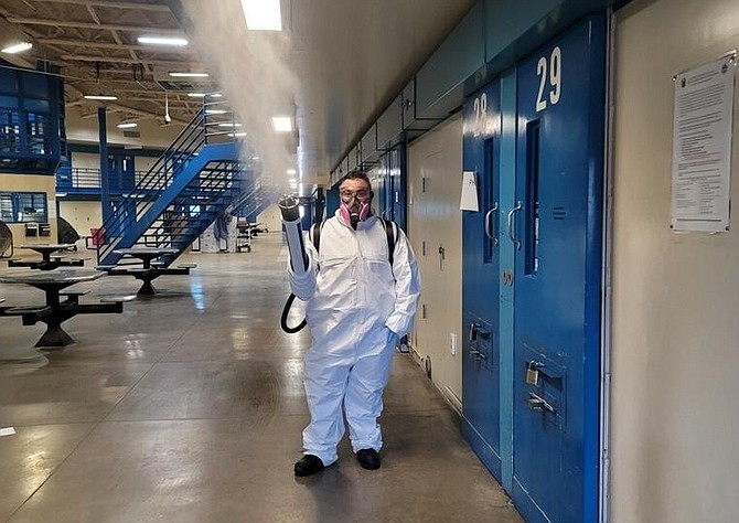 Nevada Department of Corrections Officer John Claudio-Bil disinfects a housing unit at Northern Nevada Correctional Center. 