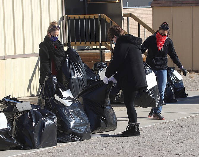 From left, Shannon Ernst, director of Churchill County Social Services, Deborah Tilley and Loretta Walker, sort out bags to give to a family participating in Wishing Tree.
