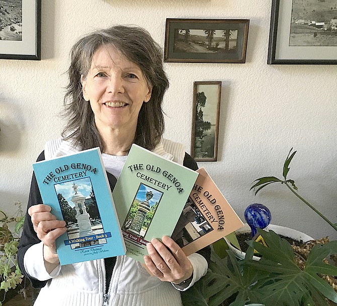 Karen Dustman holds her three Genoa Cemetery books.