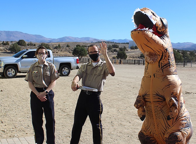 Douglas County Sheriff&#039;s Explorers hang out with a faux T-Rex on Halloween at the Fairgrounds