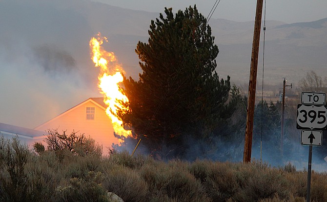 A jet of flame shoots from the rear of a home near Mottsville and Foothill Road on Tuesday afternoon.