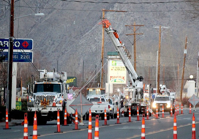 Power company workers replace a pole along Highway 395 in front of the Minden AM-PM.