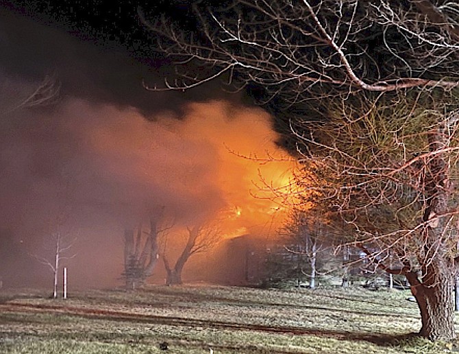 The flames from an attic fire in Genoa cast an orange glow on Monday night.