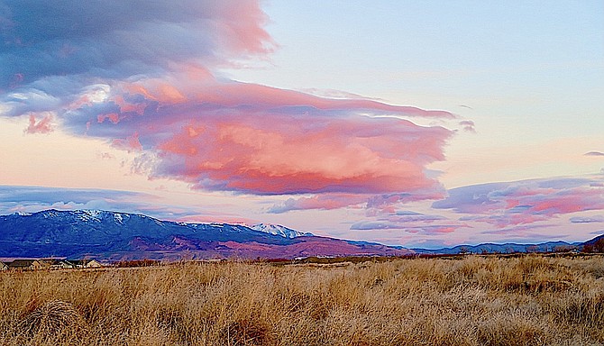 Pink puffy clouds drift across the sky on Sunday morning.