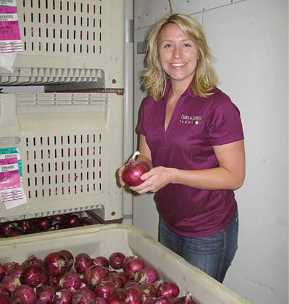 Jessica Peri inspects bins of reds as they cure in temp-controlled storage sheds.