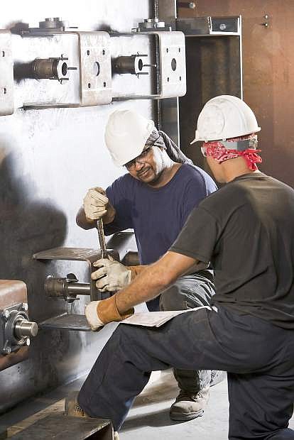Multiracial workers working on machinery in factory